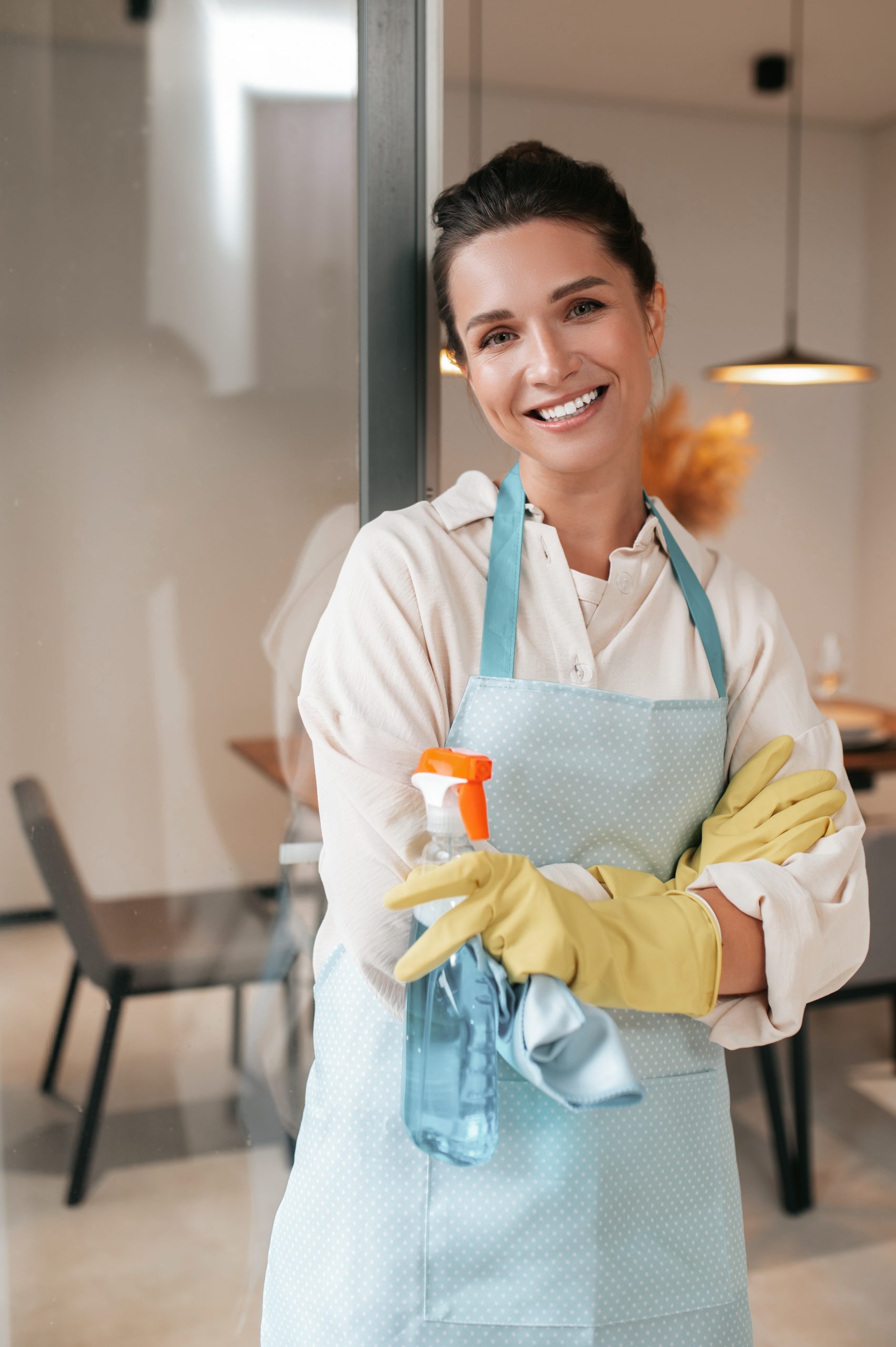 Domestic routine. Smiling housewife in apron standing in the kitchen